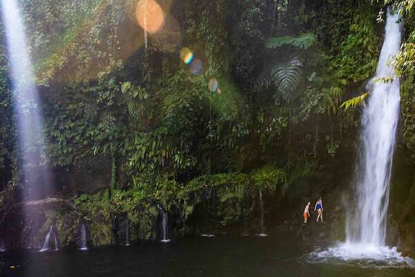 Travellers swimming in waterfall lagoon Afu Aau, Samoa