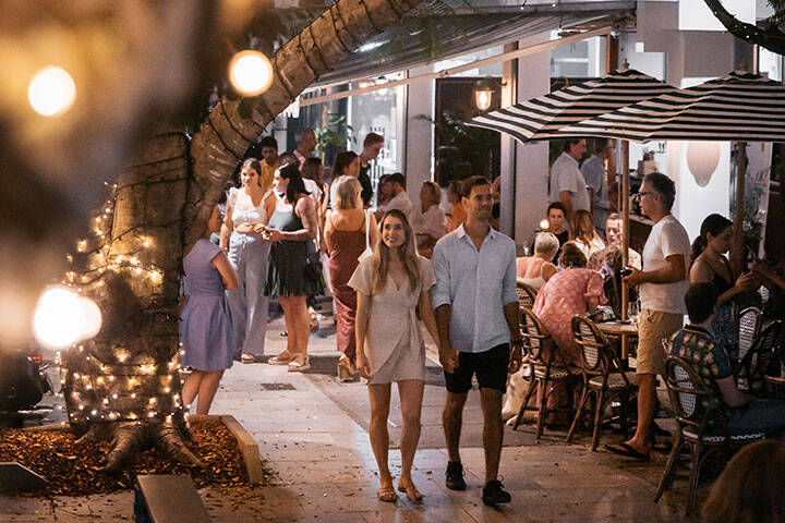 Couple walking down Hasting street, the main beachfront shopping street in Noosa 