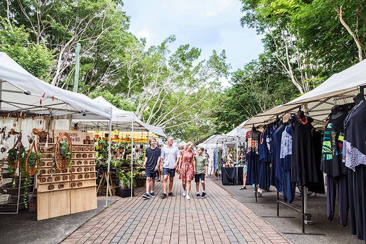 Family walking past clothing and decor stalls at Eumundi Markets 
