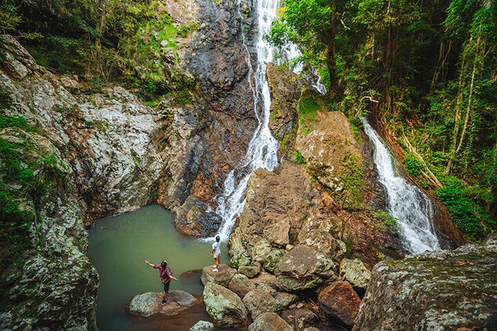 Couple standing on the rocks looking at the rock pool and Kondalilla Falls in Montville, near Sunshine Coast QLD 