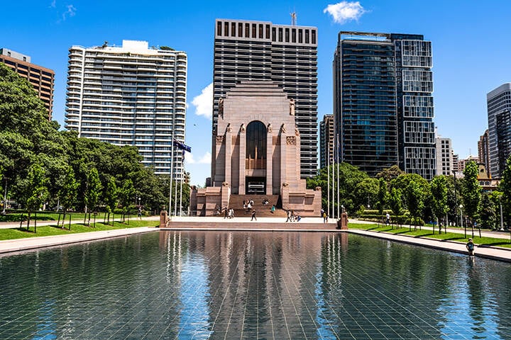 A view of the ANZAC War Memorial in Hyde Park, Sydney, surrounded by lush greenery.