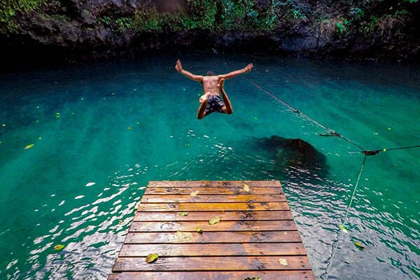 Man diving into To Sua Ocean trench in Samoa by Ethan Elisara