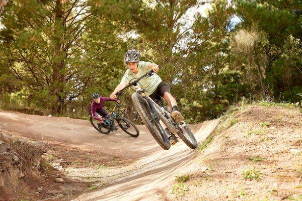 Two teenage boys riding mountain bikes on trails at the Stromlo Forest Park