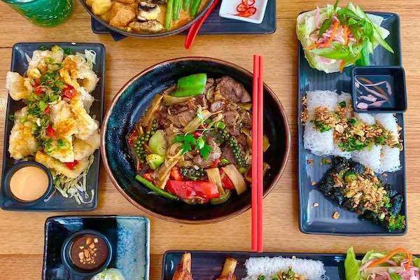 Flat lay of stir fry dishes and rice paper rolls at Chow restaurant in Darwin.