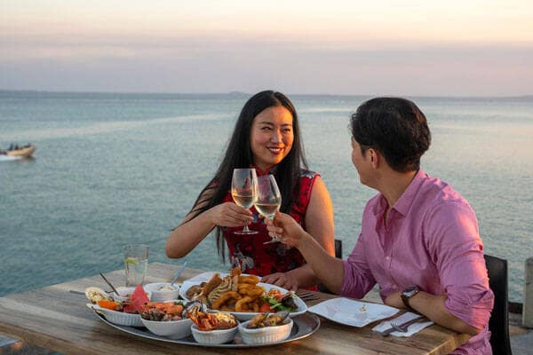 Couple enjoying sunset dinner with view of water at Crustaceans on the Wharf in Darwin.