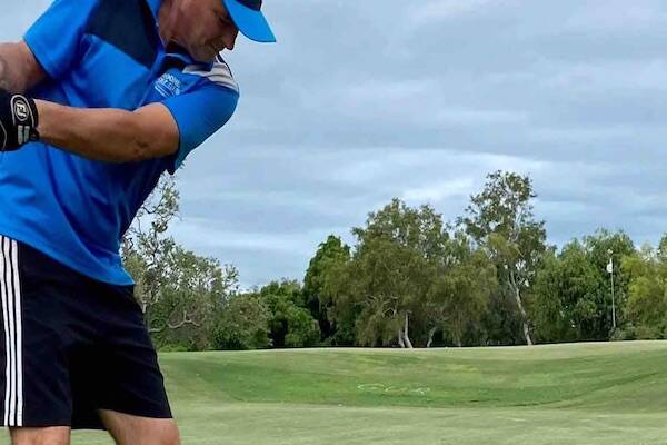 Golfer hitting ball on golfing green in Broome, Western Australia