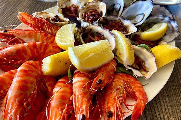 Fresh prawns and oysters presented on a platter with lemon at Oyster Bar, Darwin.