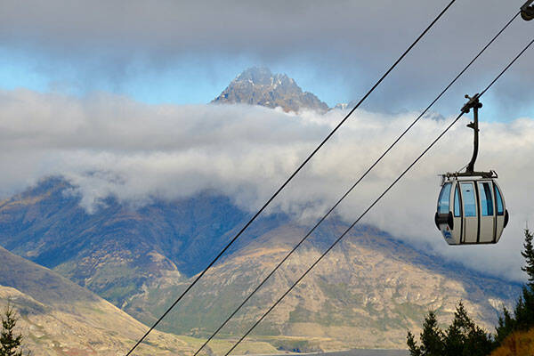 Skyline Gondola riding over trees and mountain, Queenstown by David Maunsell