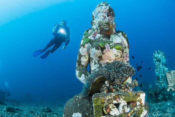 Scuba diver and underwater buddha in Bali by Sebastian Pena Lambarri