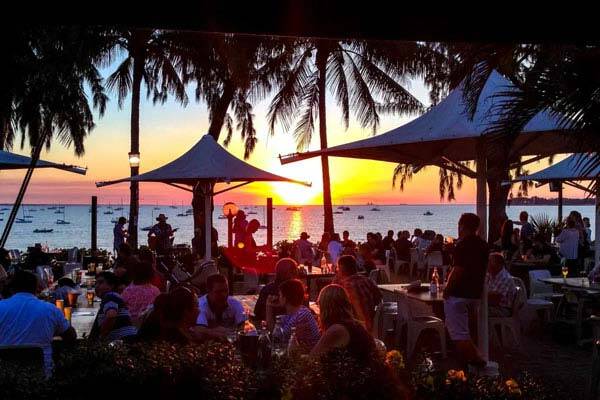 Guests sitting outdoors overlooking beachfront waterview sunset at Darwin Sailing Club.