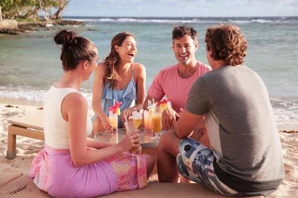 Group of friends enjoying drinks on beach Vanuatu