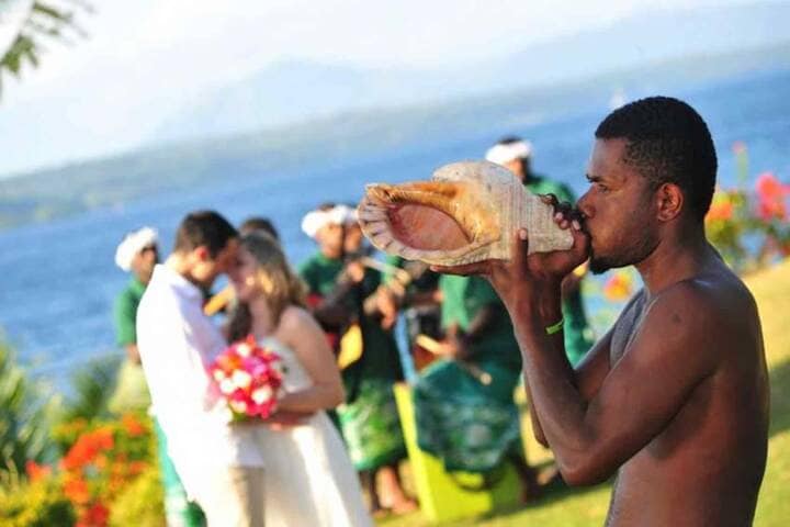 Local performing conch shell for newly married couple, Vanuatu
