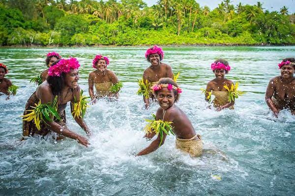 Local women in traditional wear in water celebrating Vanua Lava Arts Festival, Vanuatu