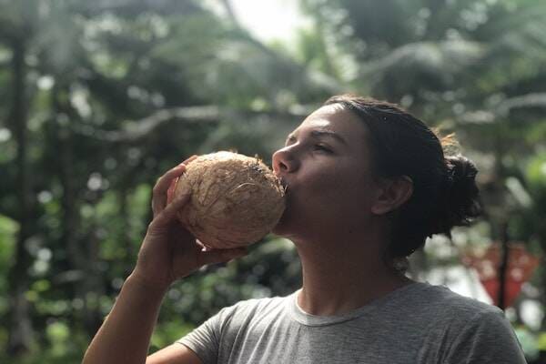 Woman sipping on coconut juice in Efate, Vanuatu 
