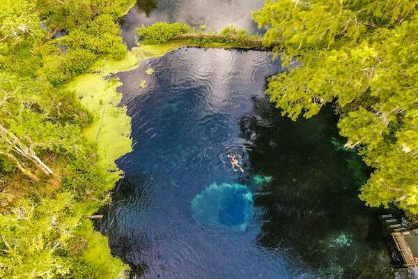 Swimmer relaxing in water at Nanda Blue Hole, Vanuatu 