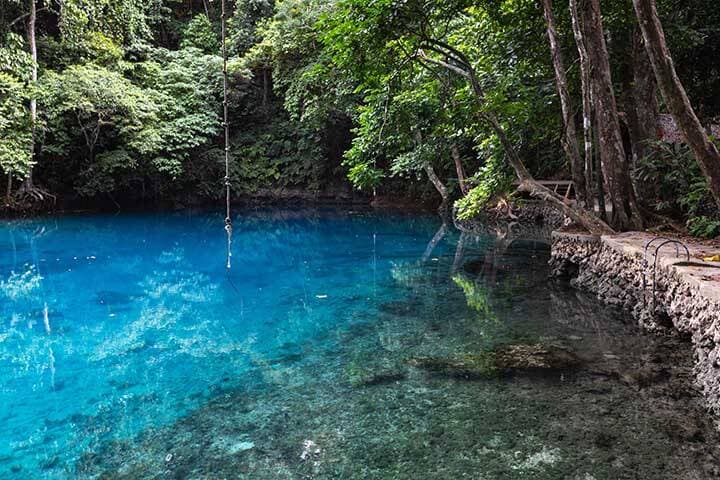 Lush rainforest and clear water at the Nanda Blue Hole