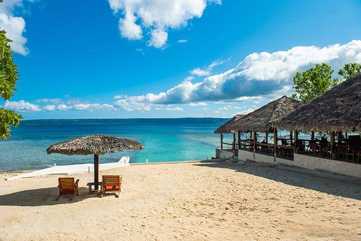 Two deck chairs on a sandy beach in Vanuatu. 