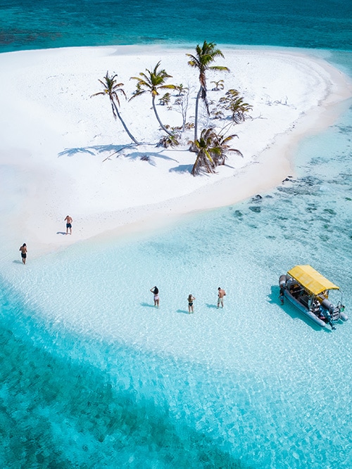 Travellers stop at a white sand atoll while exploring the Cocos Keeling Islands
