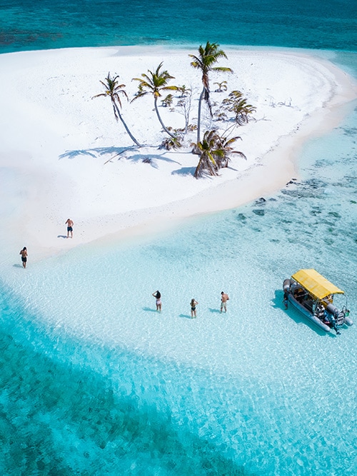 Travellers stop at a white sand atoll while exploring the Cocos Keeling Islands