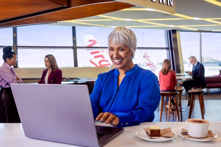 Woman typing on laptop at Virgin Australia lounge