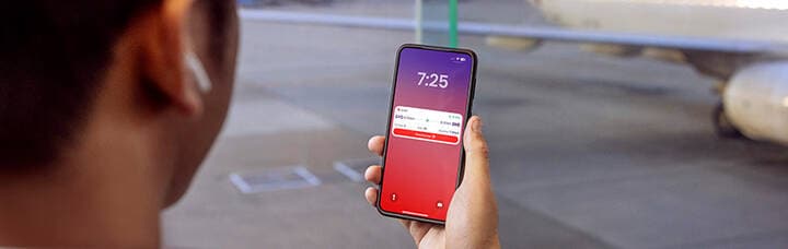 Person holding phone with Virgin Australia app.
