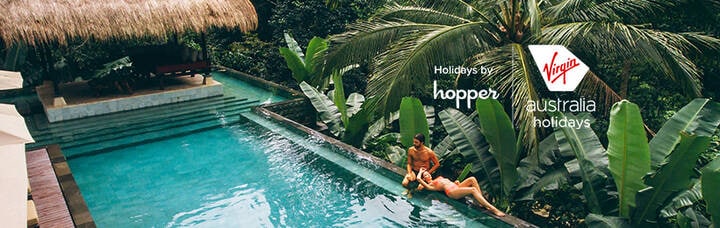 A couple lounging beside a hotel pool on holiday.