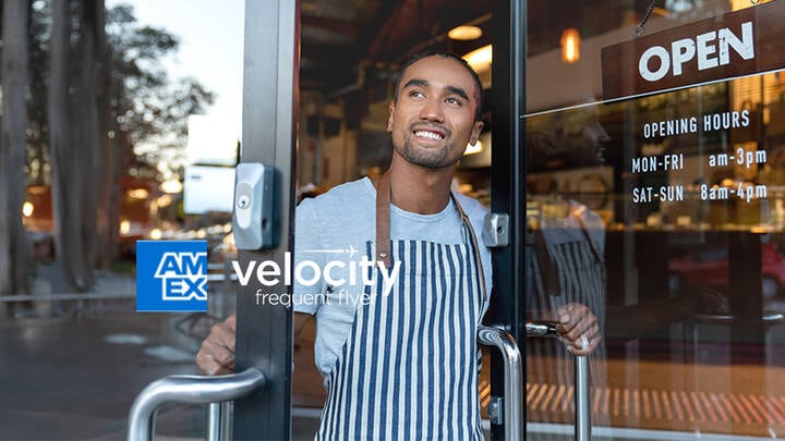 Man peering out of cafe door.
