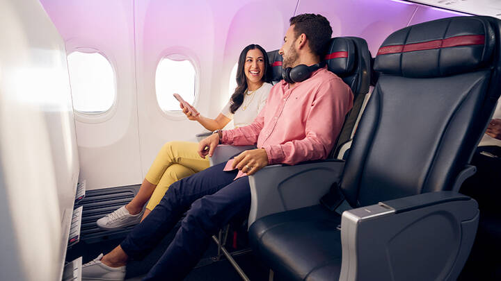 People enjoying extra legroom and priority boarding on Economy X seats.