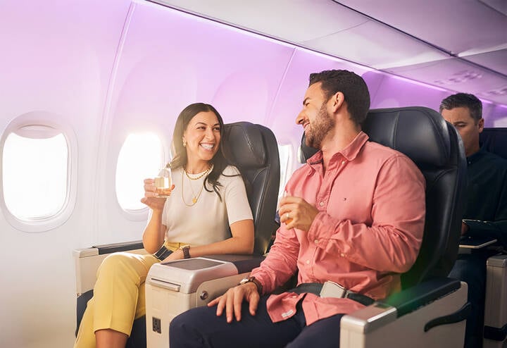 Couple enjoying business class on Virgin Australia plane.