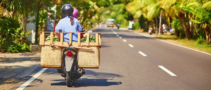 Balinese man riding scooter on road