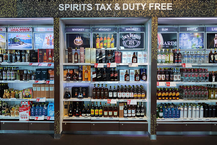 Shelves with alcoholic beverages in the tax free shopping area after departure gate for international flight of Ngurah Rai International Airport