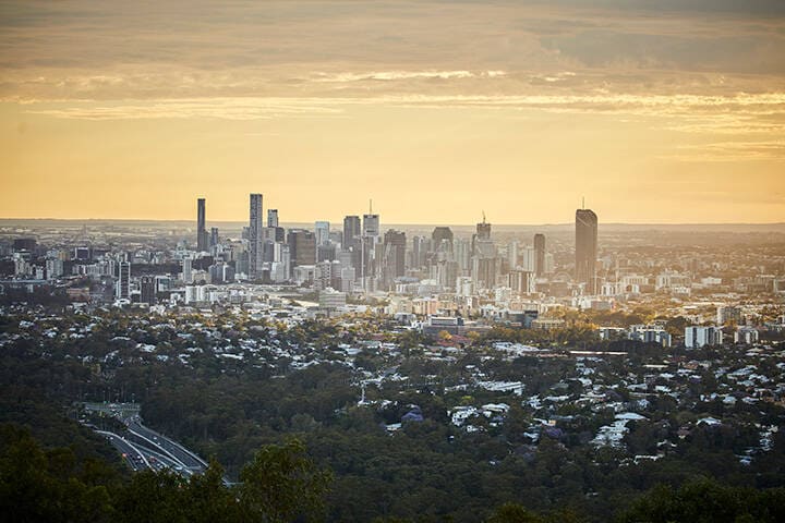 Cityscape of Brisbane with the sun shedding golden light onto the city 
