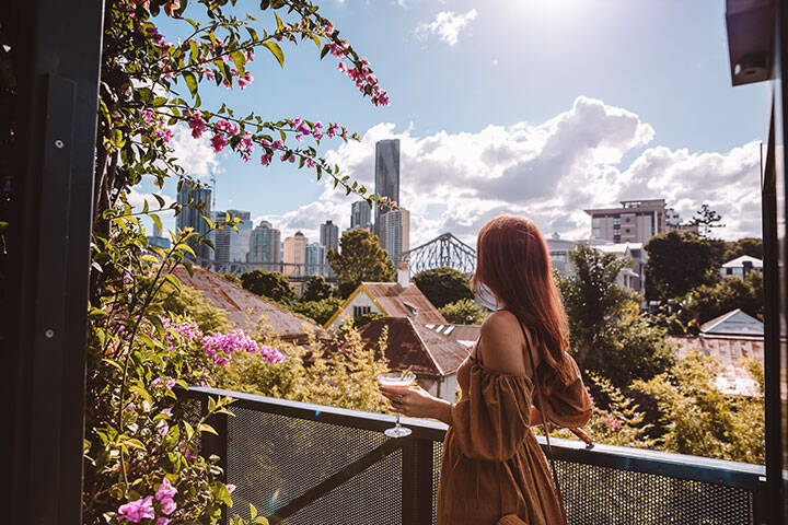 Lady enjoying a drink on a sunny, partly cloudy at the rooftop bar at Spicers Balfour Hotel 