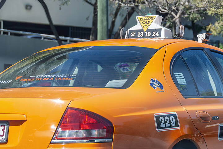 Yellow taxi in the middle of city traffic in Brisbane 