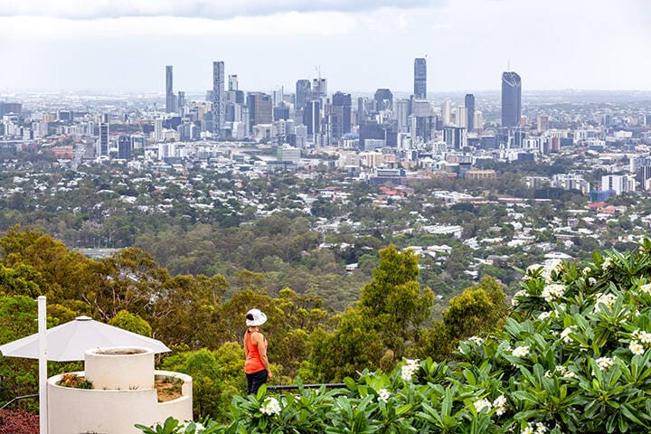 emale tourist admiring the view of Brisbane CBD from mount Coot-tha lookout