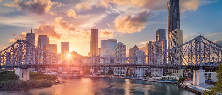 Cityscape image of Brisbane skyline, Australia with Story Bridge during dramatic sunset.