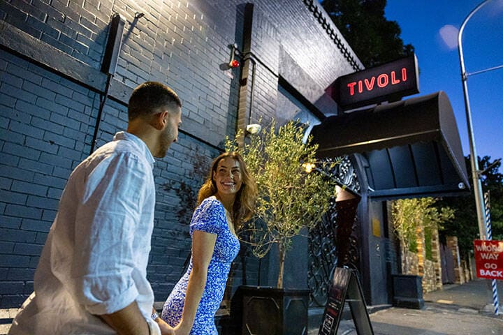 A couple holding hands and walking to The Tivoli in Fortitude Valley
