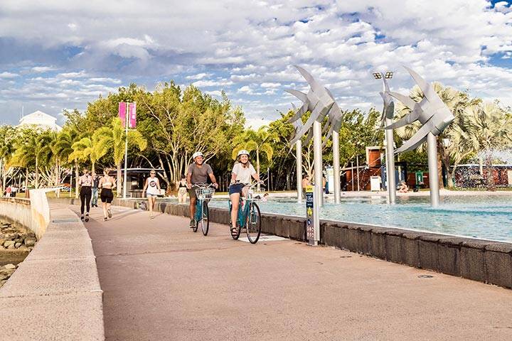 Couple bike riding along the Esplanade in Cairns