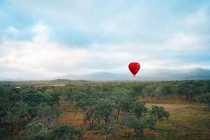 Couple enjoying a hot air balloon at sunrise high above the Atherton Tablelands