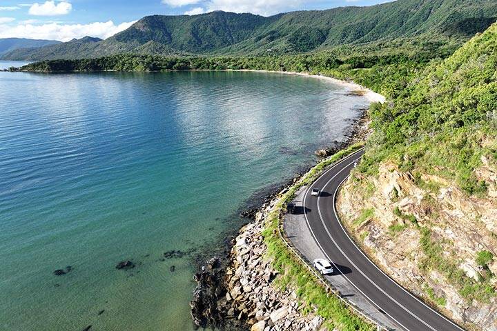 Car driving along the coastal highway between Cairns and Port Douglas