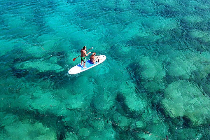 Aerial drone photo of couple practicing Stand Up Paddle or SUP in tropical Fijian waters