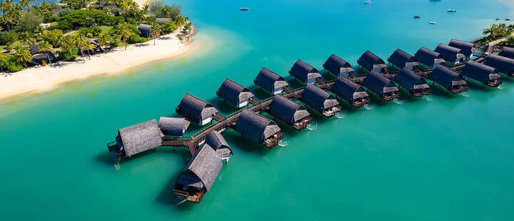 Aerial view of overwater bures in Momi Bay, a luxury resort in Fiji