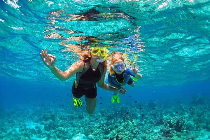 Mother and child snorkelling with masks and flippers. 