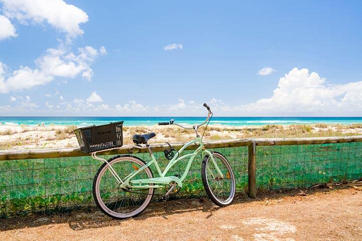 A bicycle leans against a fence at Kirra Beach, Gold Coast, Queensland, Australia. 