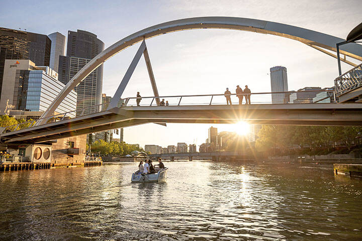 Tourists enjoying a river boat cruise on the Yarra in Melbourne on a clear, sunny day.  