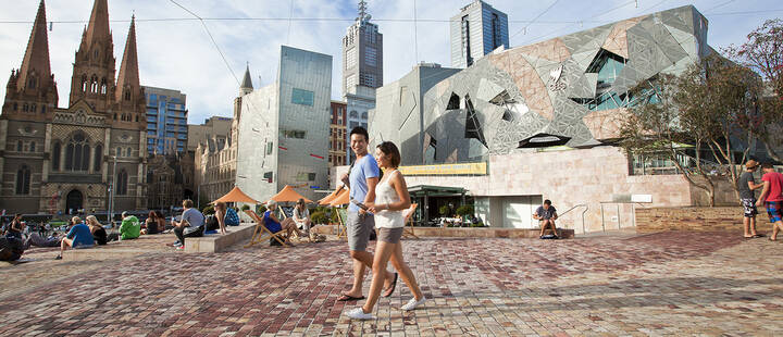 Couple walking through Federation Square 