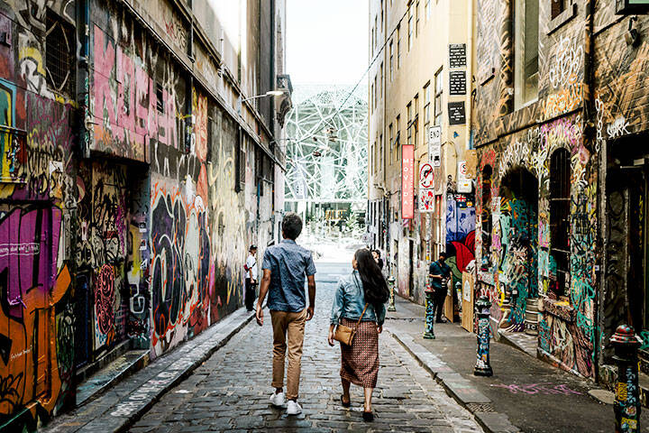 Tourists walking through graffiti laneways in Melbourne CBD