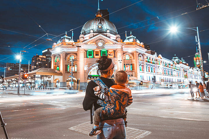 Traveller and baby outside Flinders St Staion at night