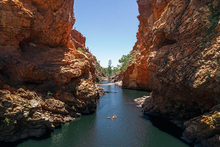 Swimming at Ellery Creek Big Hole. Ellery Creek Big Hole is one of the most popular and picturesque camping, walking, swimming and picnic spots in the Tjoritja / West MacDonnell National Park.  The spectacular waterhole is fed by the West MacDonnell Ranges (Tjoritja) and surrounded by high red cliffs and sandy Ellery Creek.  West MacDonnell is a national park in the Northern Territory (Australia) west of Alice Springs. It extends along the MacDonnell Ranges west of Alice Springs.