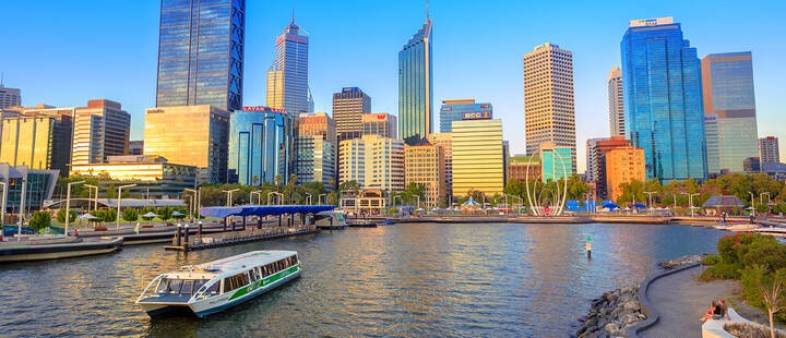 Ferry in Elizabeth Quay Marina at sunset with skyscrapers of Central Business District on background in Perth, Western Australia.  